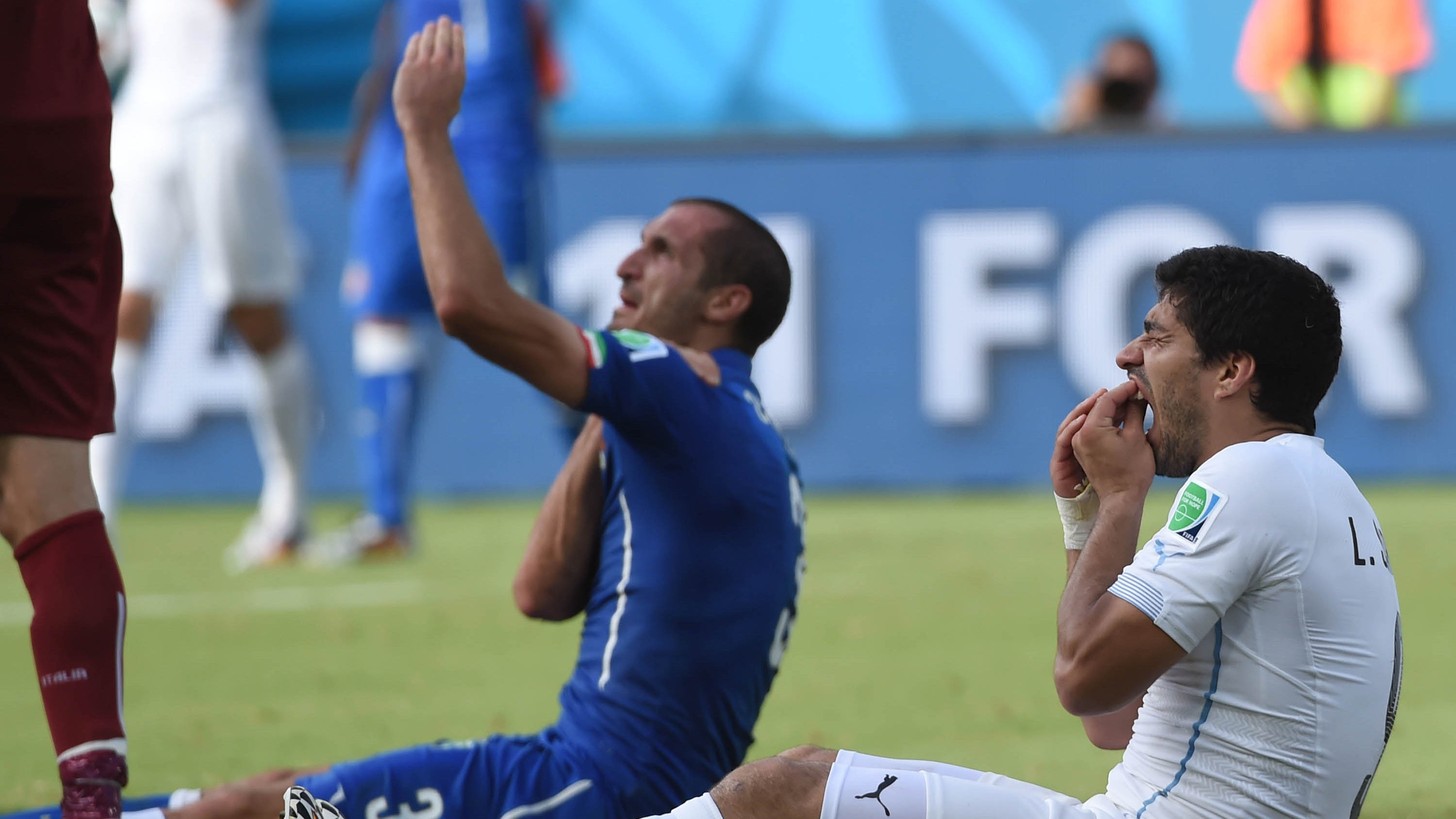 Fußballer Luis Suarez (r.) hat zugebissen. Sein Gegenspieler und Opfer beschwert sich, Suarez tun die Zähne weh.