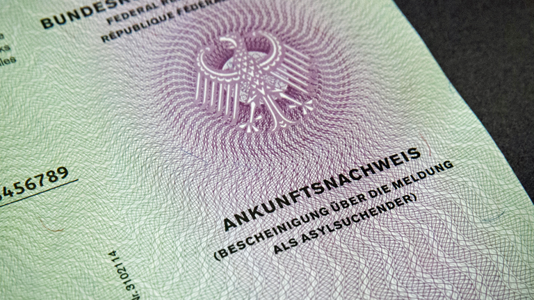 Bundesinnenminister Thomas de Maiziere (CDU) zeigt am 09.12.2015 in Berlin den neuen Flüchtlingsausweis.