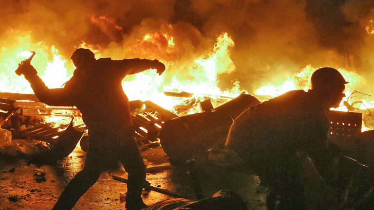 Gewalt in der Ukraine am 18.02.2014: In Kiew wirft ein Mann vor einer Feuerkulisse einen Molotow-Cocktail.