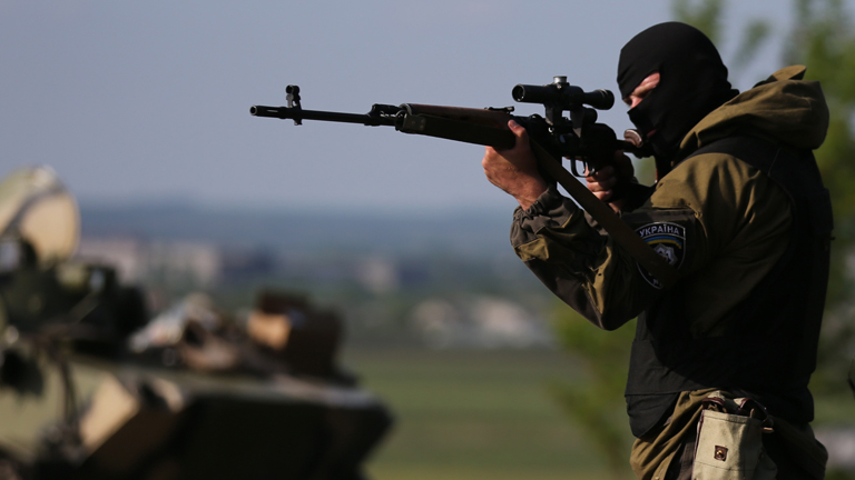 Am 04.05.2014 steht ein maskierter ukrainischer Soldat mit einem Scharfschützengewehr an einen Kontrollpunkt bei Kharkov-Rostov.
