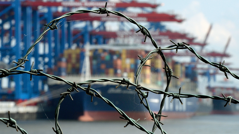 Stacheldraht ist am 05.07.2014 im Hafen in Hamburg vor einem Containerschiff zu sehen.