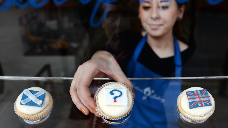 Am 16.09.2014 platziert die Mitarbeiterin einer Bäckerei kleine Küchlein im Schaufenster: Sie tragen die schottische und die englische Flagge sowie dazwischen ein Fragezeichen.