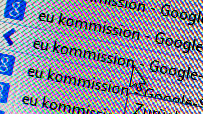 Auf einem Monitor zeigt die Google-Suche Ergebnisse zur EU-Kommission an.