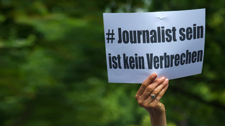 "Journalist sein ist kein Verbrechen" steht am 21.06.2015 in Berlin auf einem Papier, das eine Frau vor einer Polizeistation hält, um für die Freilassung des Al Jazeera-Journalisten Ahmed Mansour zu demonstrieren.