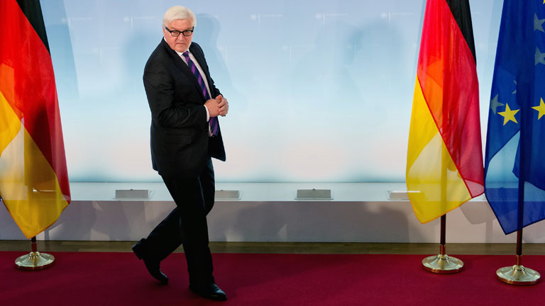 Bundesaußenminister Frank Walter Steinmeier zwischen Deutschland- und Europafahnen.