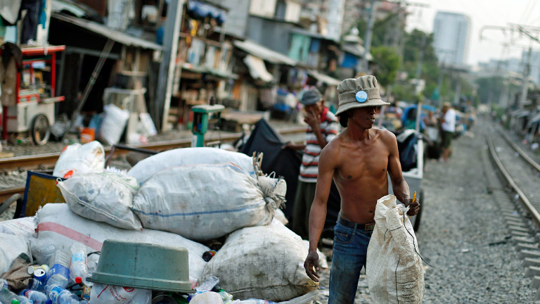 Ein Indonesier steht an einem Eisenbahngleis.