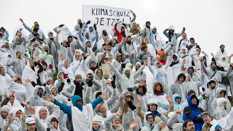 Zahlreiche weiß gekleidete Menschen bilden am 28.11.2015 in München (Bayern) auf dem Olympiaberg mit weißen Umhängen einen symbolischen Gletscher um ein Zeichen für den Klimaschutz zu setzen.