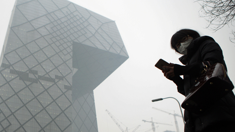 Peking ist am 08.12.2015 in Smog getaucht, ein Fußgänger trägt eine Schutzmaske.