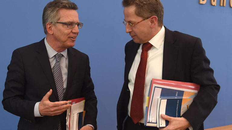 Bundesinnenminister Thomas de Maiziere (CDU, l) und Hans-Georg Maaßen, der Präsident des Bundesamtes für Verfassungsschutz, unterhalten sich am 18.06.2014 nach einer Pressekonferenz in Berlin, auf der sie den Verfassungsschutzbericht 2013 vorgestellt hatten.