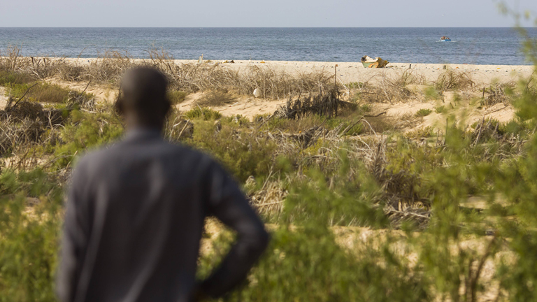 Mann steht am Strand
