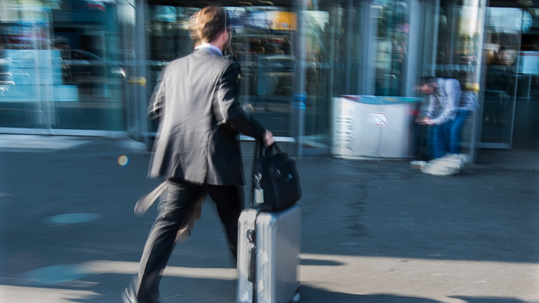 Ein Mann mit Rollkoffer geht am 21.05.2015 in den Hauptbahnhof in Berlin.