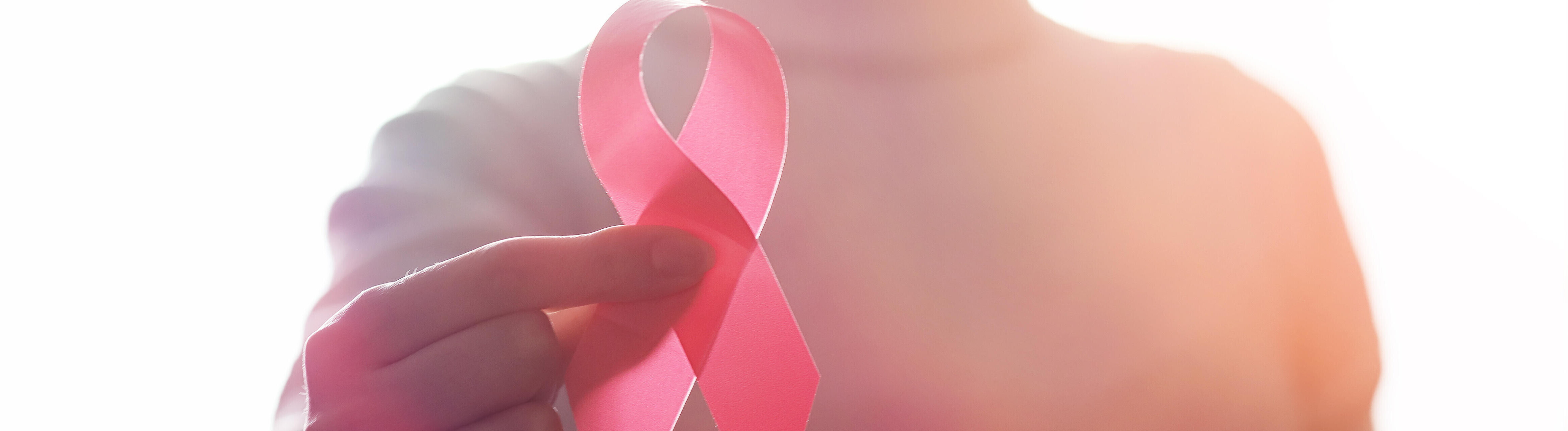Ein Mensch hält eine große Schleife hoch, Symbol für Kampf gegen HIV