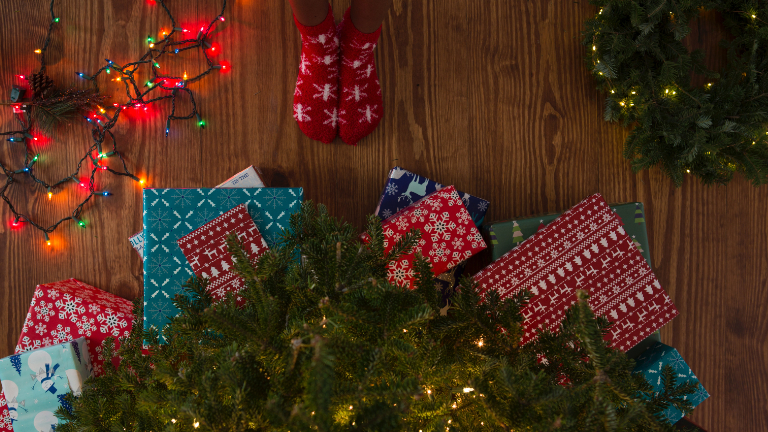 Weihnachtsgeschenke liegen auf dem Boden.