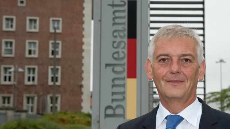 Manfred Schmidt, Präsident des Bundesamts für Migration und Flüchtlinge, posiert am 17.08.2015 in Nürnberg (Bayern) vor dem Bundesamt für Migration und Flüchtlinge (BAMF) vor einer Kundgebung von Flüchtlingen für ein Foto.