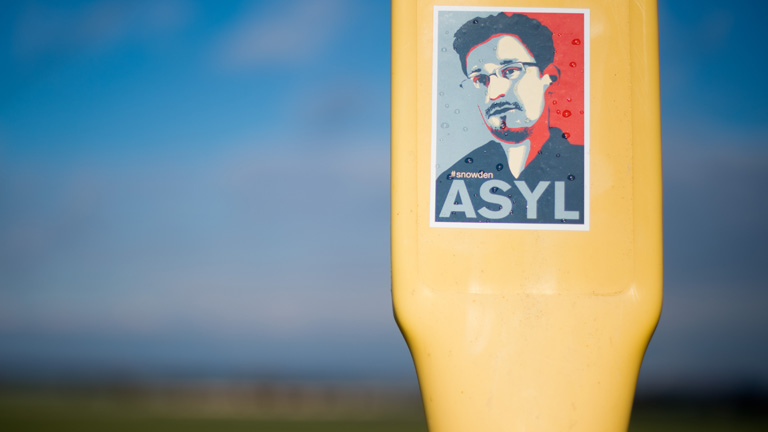 Ein Aufkleber, mit dem Asyl für den Informanten Edward Snowden gefordert wird, klebt am 11.02.2014 auf einem Masten bei Beckedorf im Landkreis Schaumburg (Niedersachsen).