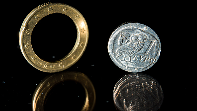 Eine auseinandergebrochene Euro-Münze aus Griechenland liegt am 05.01.2015 auf einem Tisch.