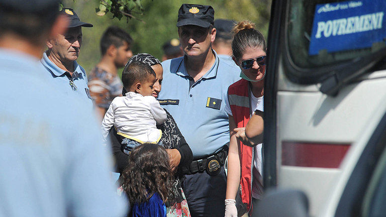 Kroatische Polizisten führen Flüchtlinge zu einem Bus