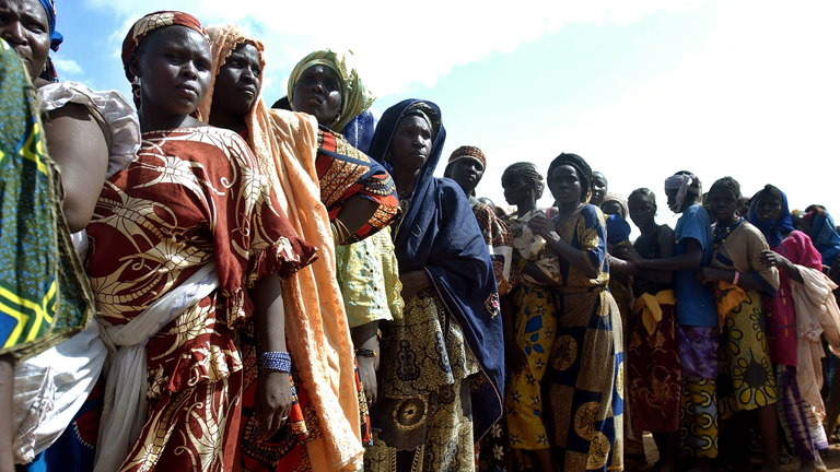 Frauen stehen in Tilaberi, Niger, für Getreide an