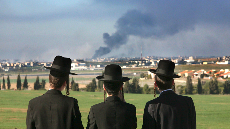 Ultra-orthodoxe Juden blicken auf Rauch, der aus dem Gazastreifen aufsteigt