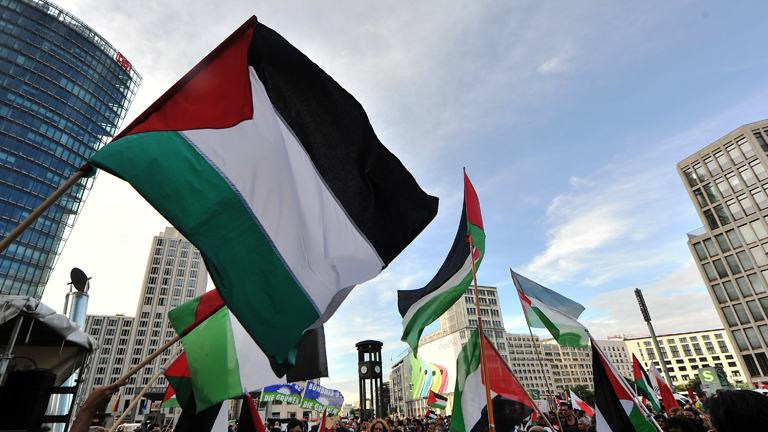 Menschen mit Palästinenser-Fahnen stehen am 09.08.2014 in Berlin bei einer Pro-Palästina-Demonstration auf dem Potsdamer Platz.