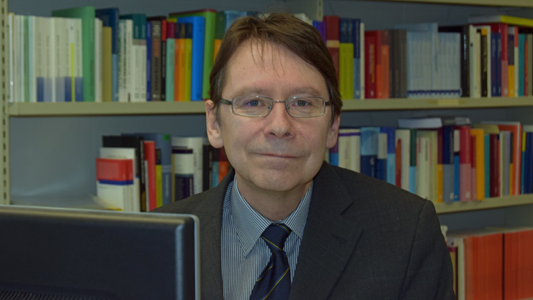 Der Politikwissenschaftler Uwe Jun sitzt am 9. Februar 2016 in Trier an seinem Büroschreibtisch
