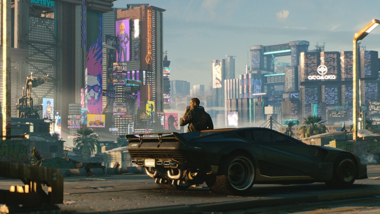 Screenshot aus dem Spiel Cyberpunk 2077: Ein Mann lehnt an einem schwarzen Sportauto und blickt auf die Skyline der Stadt