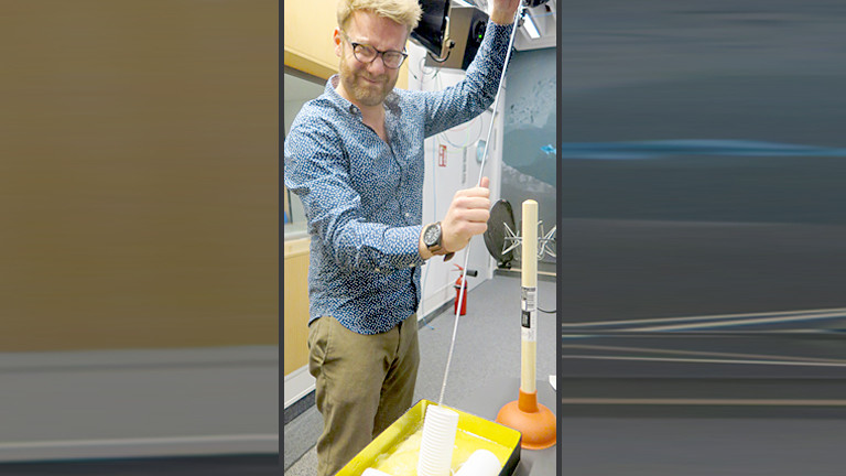 Mann reinigt ein Stück Rohr.