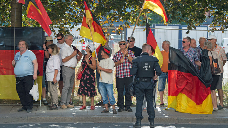 Pegidademonstranten und ein Polizist am 16. August in der sächsischen Landeshauptstadt Dresden