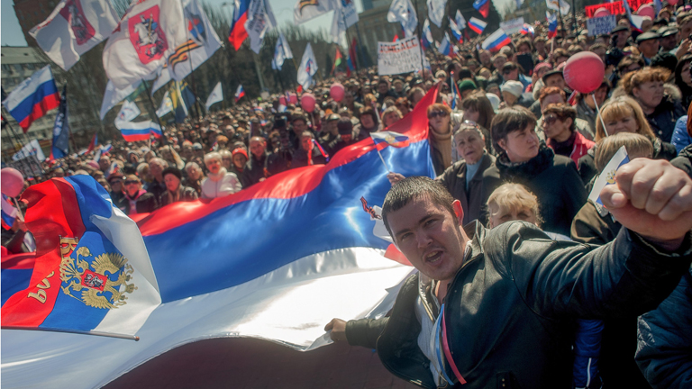 Prorussische Demonstranten in Donezk tragen eine riesige russische Fahne durch die ukrainische Stadt.