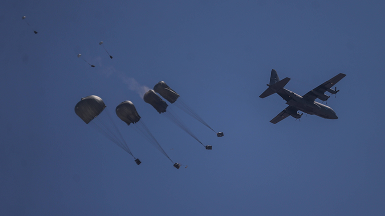Ein Flugzeug wirft Hilfsgüter mit Fallschirmen ab