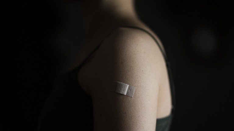 Schulter einer Frau. auf der ein Pflaster klebt