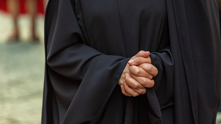 Nahaufnahme einer Frau, die ihre Hände zum Gebet faltet