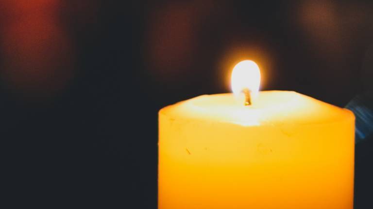 Brennende Kerze in Dunkelkeit