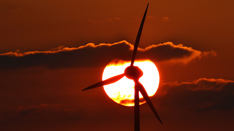 Ein Windrad steht am 24.06.2014 bei Ebersbach (Bayern) vor der tief stehenden Sonne.