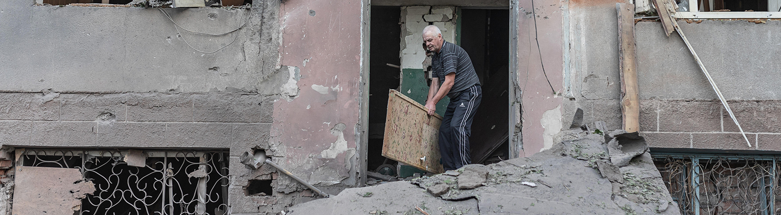Ein Mann in der Ukraine räumt Kriegs-Trümmer weg