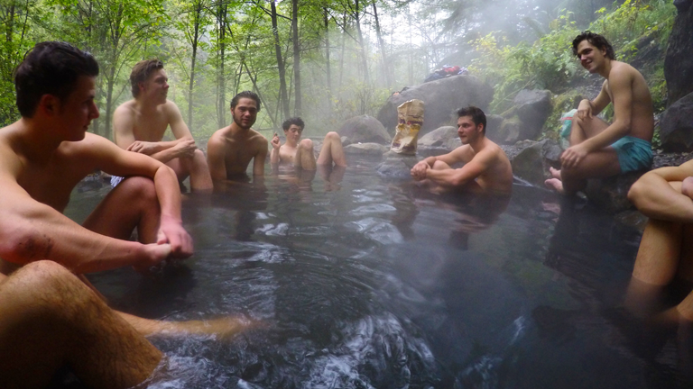 Junge Männer baden in einer heißen Quelle