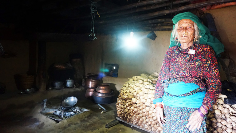 Zum ersten Mal im Leben elektrisches Licht : eine Dorfbewohnerin in ihrer Lehmhütte - Nepal