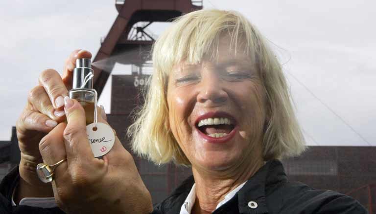 Portrait von Sissel Tolaas mit einem Duft-Zerstäuber in der Hand