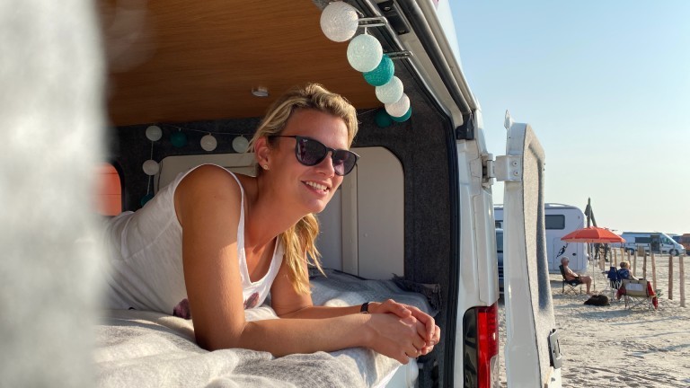 Isa in ihrem Bus am Strand in Sankt Peter Ording.