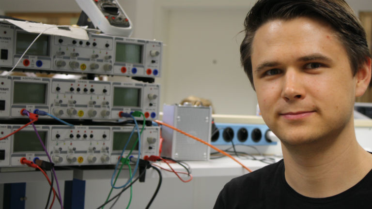 Ein junger Mann vor elektronischen Maschinen.