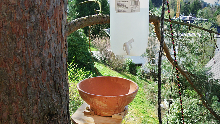 Ein Blumenkübel als Waschbecken und ein Wasserkanister