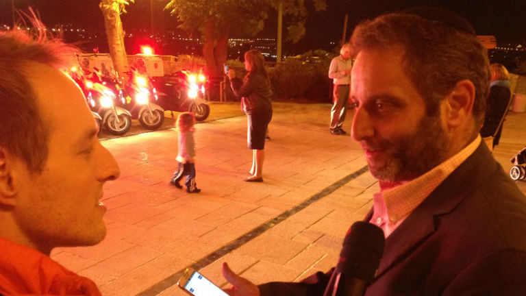 Ein Reporter interviewt einen Mann mit Smartphone in der Hand.