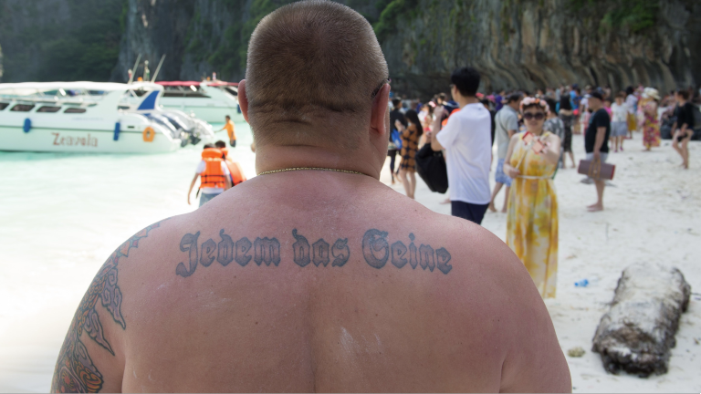 Neo-Nazi Neo-Nazi mit Tattoo "Jedem das Seine" steht am Strand von Maya Bay auf Ko Phi Phi Leh, Thailand, aufgenommen am 23.07.2017.