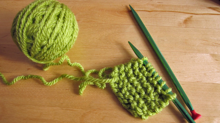 Ein grüner Topflappen wird gestrickt.
