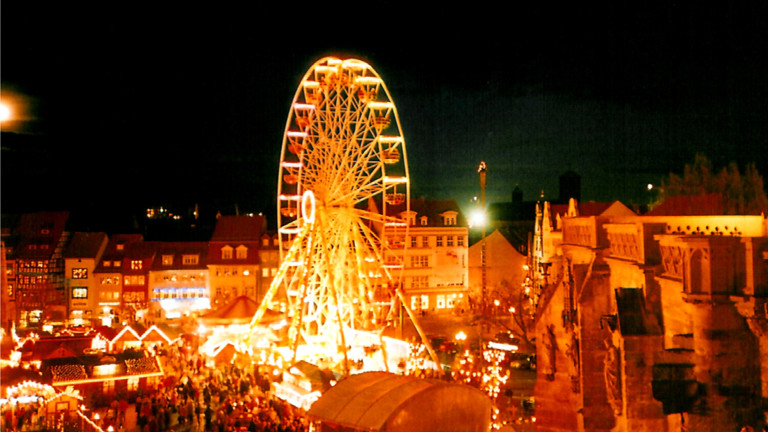 Weihnachtsmarkt bei Nacht mit Riesenrad.