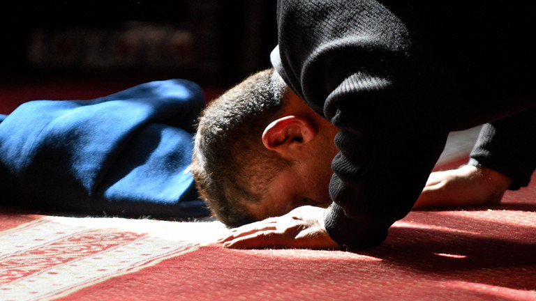 Ein Moslem betet mit dem Kopf am Boden.