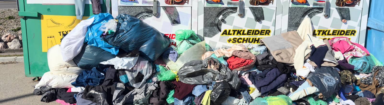 Mehrere überfüllte Altkleidercontainer.