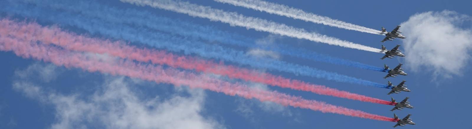 Die russischen Luftstreitkräfte fliegen bei der Militärparade über den Roten Platz und bilden mit farbigen Raum die russische Staatsflagge.