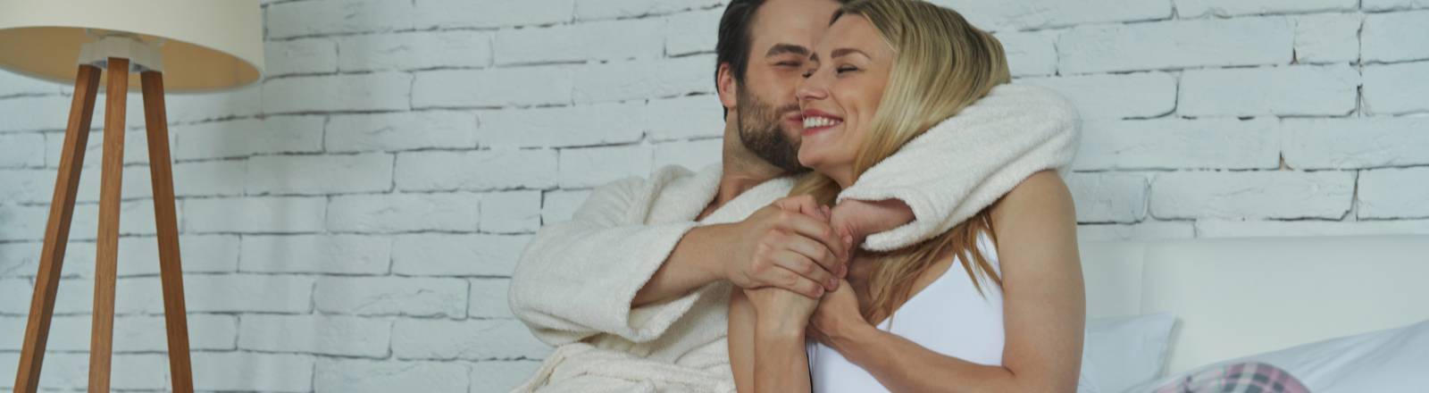 Ein verliebtes Pärchen frühstückt nach dem Aufwachen im Bett.