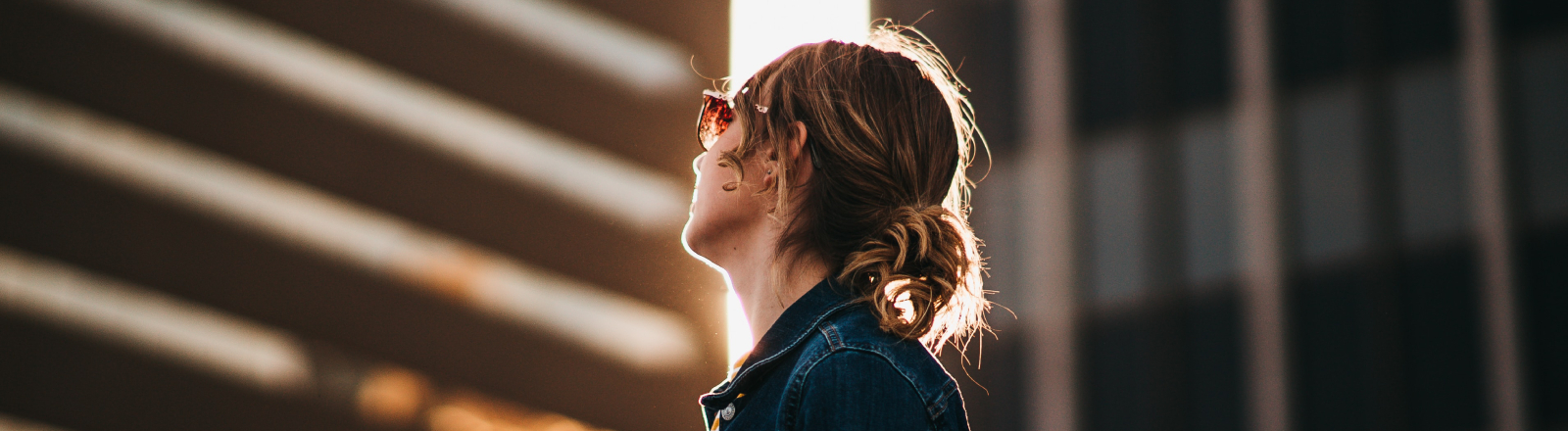 Eine Frau blickt nach oben zu einem Bürogebäude.